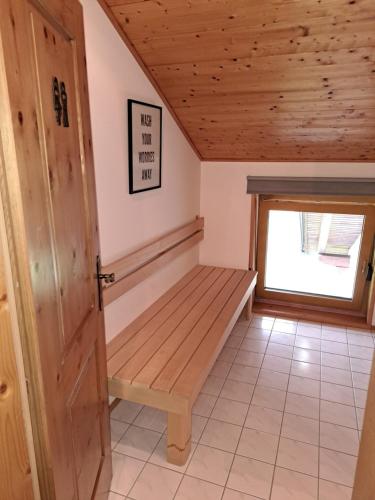 a room with a wooden bench in a house at atHOME Appartements in Rattendorf