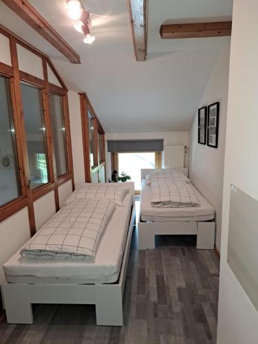 two beds sitting in a room with windows at atHOME Appartements in Rattendorf