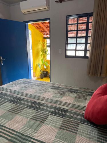 a bedroom with a bed with a red pillow on it at Pousada Recanto do Tucano in Cavalcante