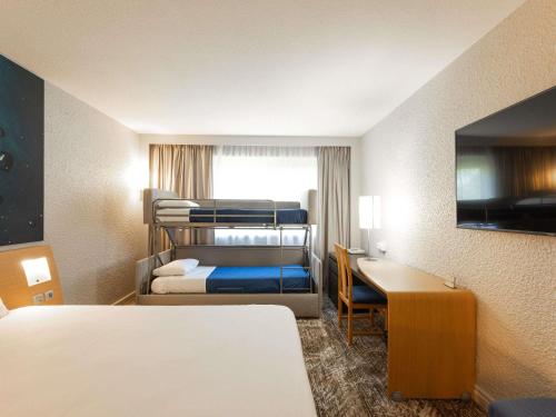 a hotel room with two bunk beds and a desk at Novotel Macon Nord - Porte de Bourgogne in Mâcon