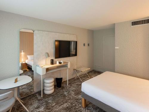 a hotel room with two beds and a desk at Novotel Macon Nord - Porte de Bourgogne in Mâcon