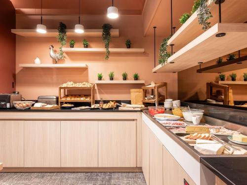 a kitchen with a counter with food on it at Novotel Macon Nord - Porte de Bourgogne in Mâcon