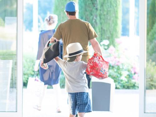 a young boy holding a hat and shopping bags at Novotel Strasbourg Centre Halles in Strasbourg
