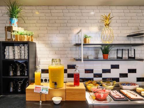 a kitchen with a counter with orange juice at Novotel Le Mans in Le Mans