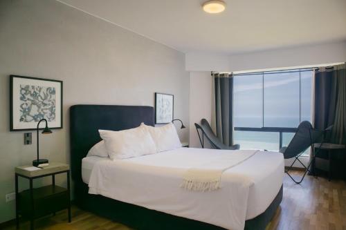 Una habitación de hotel con una cama y una ventana. en Industrial 3BR With OCEAN View, en Lima
