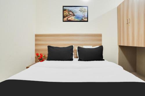 a bedroom with a large white bed with two pillows at Hotel O XOTEL Near HSR in Bengaluru