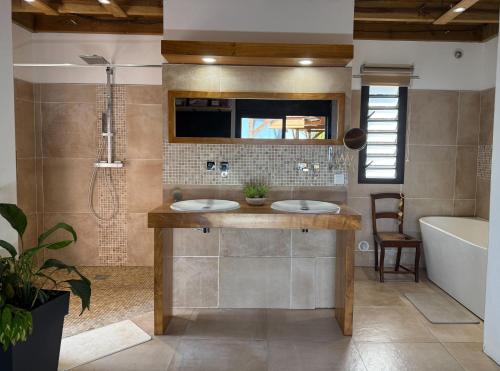 a bathroom with two sinks and a bath tub at Villa Le Gillaou in La Possession