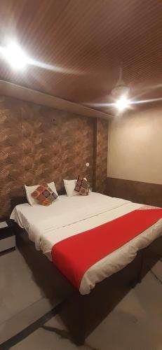 a bedroom with a large bed with a red blanket at Hotel Metro Residency Kalkaji in New Delhi