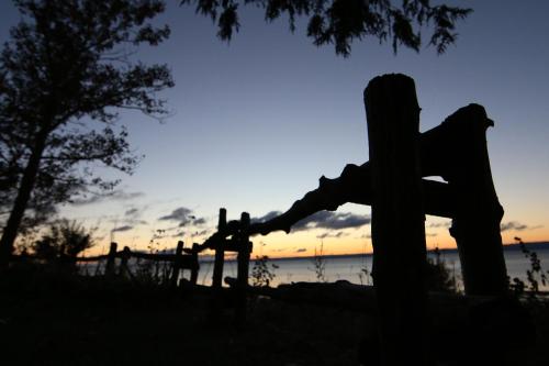 a silhouette of a wooden cross with the sunset in the background at Auberge La Coudriere (Cool Hotel) in L'Isle-aux-Coudres