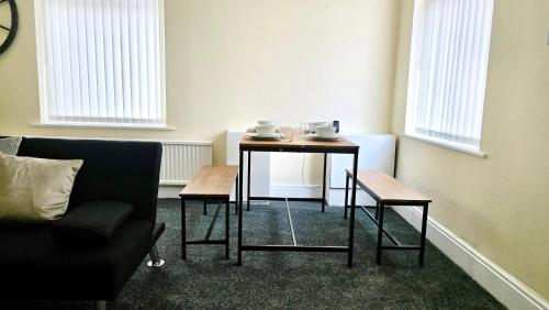 a living room with a table and a couch at Comfy Entire Apartment with Free Parking in Bury Town in Bury