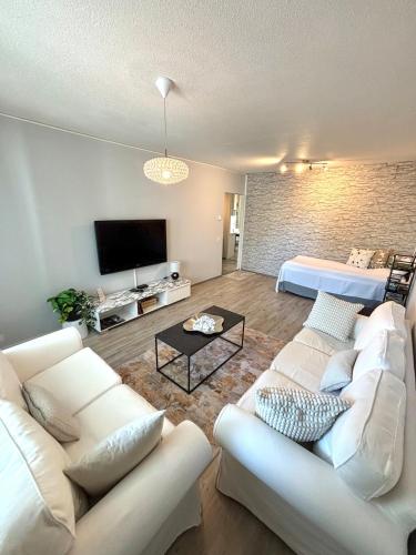 a living room with two white couches and a bed at Stylish two-rooms and kitchen apartment 66 m2 in Turku
