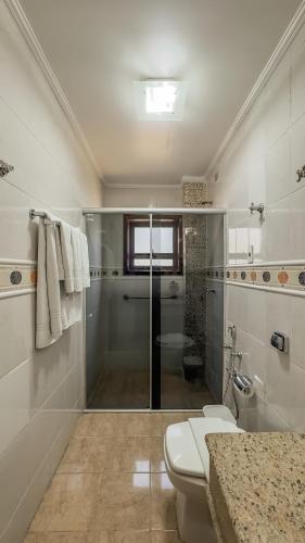 une salle de bain avec une douche, des toilettes et un lavabo dans l'établissement Pousada Vilage Inn Capivari Campos do Jordão, à Campos do Jordão