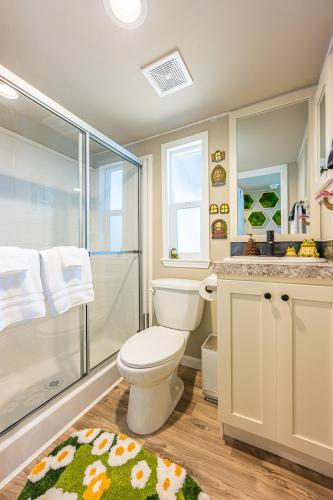 a bathroom with a toilet and a glass shower at Rainforest Tiny Home Retreat Enchanted in Forks