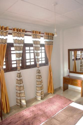 a room with curtains on the wall and a table at Misty Morning Villa Ella in Ella