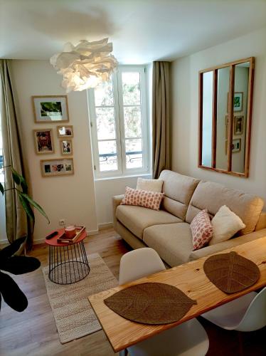 a living room with a couch and a table at Gites les Pourquoi Pas - Résidence de Tourisme DSV Bayeux in Bayeux