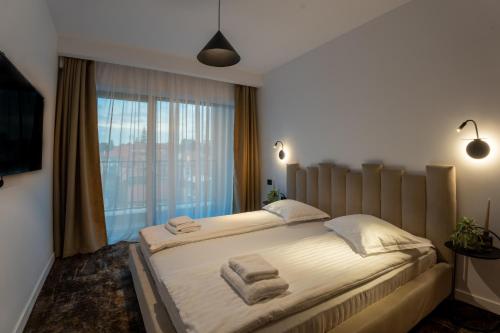 ein Schlafzimmer mit einem großen Bett, auf dem Handtücher liegen in der Unterkunft Cuza 16 - Central Premium Apartments in Braşov