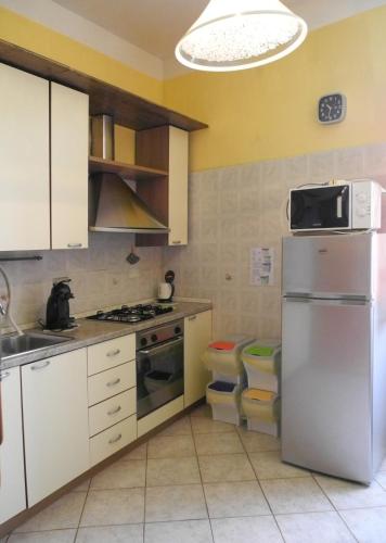 a kitchen with white cabinets and a stainless steel refrigerator at La Spezia Marola Un Borgo Sul Mare in La Spezia