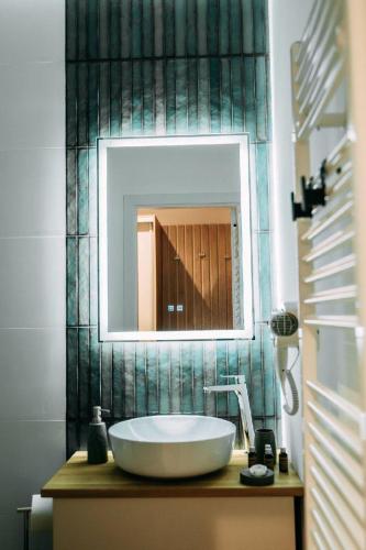 a bathroom with a large white sink and a mirror at Casa Dragan in Baile Felix