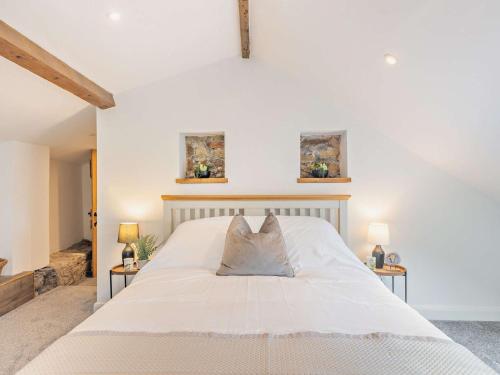 Un dormitorio con una gran cama blanca con dos mesas. en 4 Bed in Mold 92663, en Treuddyn