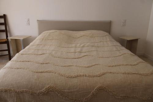 a bed with a brown blanket on top of it at Le Laoul cottage 2 people in Bourg-Saint-Andéol