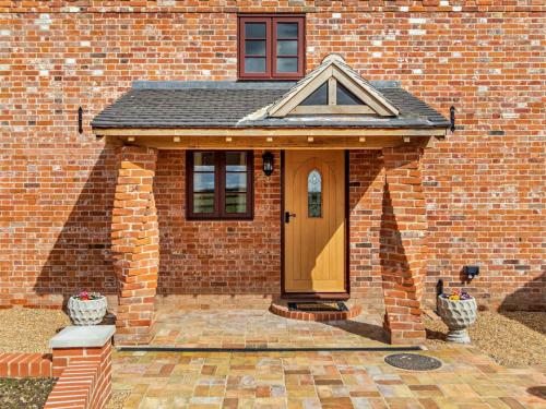 a brick house with a wooden door in the front at 3 Bed in Repps with Bastwick 94054 in Potter Heigham