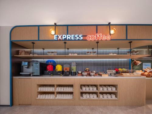 a coffee shop with a sign that reads express coffee at Holiday Inn Express Rizhao Oriental Colorful City in Rizhao