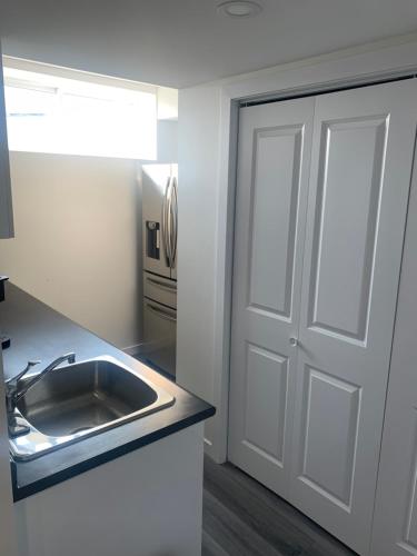 a kitchen with a sink and a door at Friendly Extended Stay and Comfort in Winnipeg