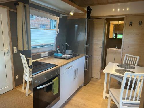 a kitchen with a stove and a sink and a table at Tiny House auf dem Lande in Hilders