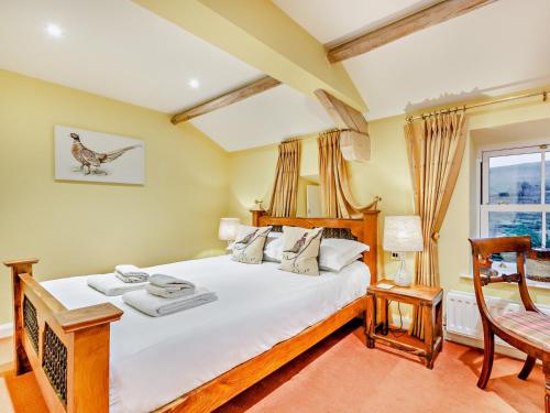a bedroom with a bed and a chair and a window at 1 Bed in Hawes 94120 in Hawes