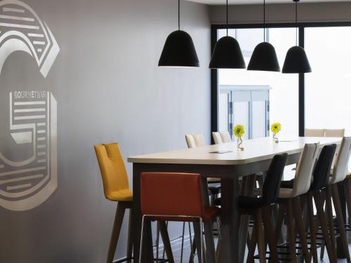 a dining room with a table and chairs at Novotel Roissy Saint Witz in Saint-Witz