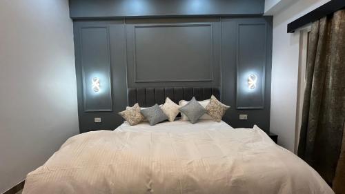 a bedroom with a large white bed with four pillows at Isha Homes in Greater Noida