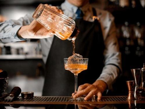 a bartender is making a drink in a glass at Novotel Antwerpen - Ekeren in Antwerp