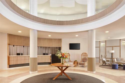 a lobby with a table with flowers on it at NH Marina Portimao Resort in Portimão