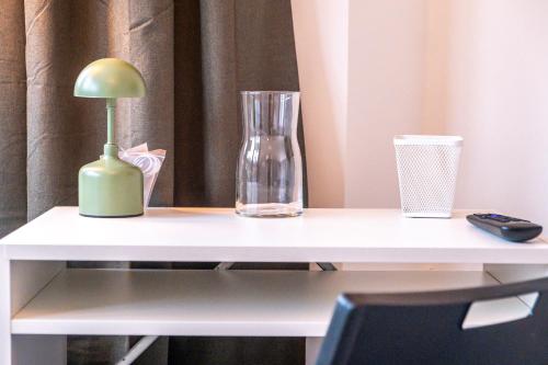 a white desk with a vase and a lamp on it at Studio, 30min Wembley Stadium & Central London, Coldplay, Lady Gaga, Parking, lovely toiletries in Colindale