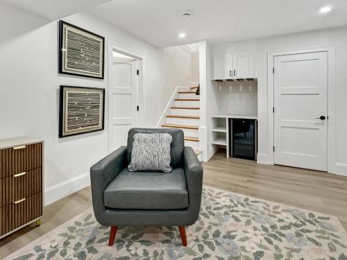 a living room with a chair and a staircase at Forest Hill condos -Boston in Boston