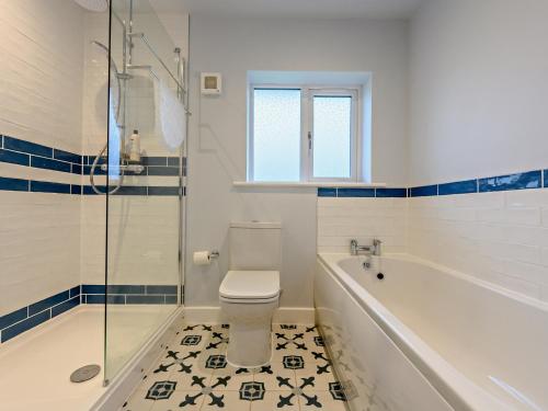 a bathroom with a toilet and a tub and a shower at 3 Bed in Threlkeld 93589 in Threlkeld