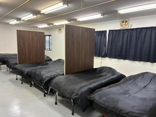 a row of beds in a room with curtains at K5 Building - Vacation STAY 20273 in Nabegayato
