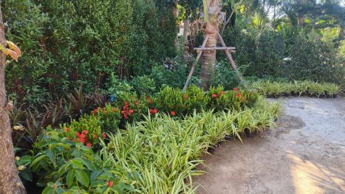 a garden with flowers and a tripod in the middle at Private Garden Villa Koh Lanta in Phra Ae beach