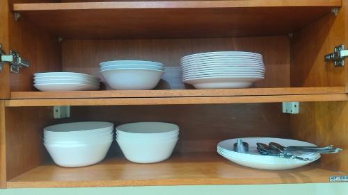 a shelf with white bowls and plates on it at Private Garden Villa Koh Lanta in Phra Ae beach