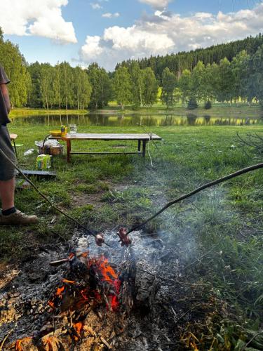 a man standing next to a fire in a field at Chlistovský rybník 