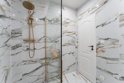 a bathroom with a shower with marble walls at Resort Červený dvůr in Rapotín