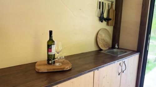 una bottiglia di vino e due bicchieri su un bancone di Glamping Všímarský Stream a Malšín