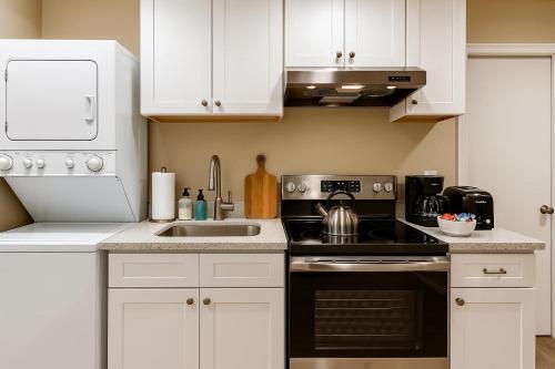 a kitchen with white cabinets and a black stove top oven at Homey 1BR APT in SSFO with Washer Dryer WiFi in Westborough