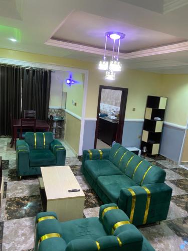 a living room with green couches and a table at MARIAN APARTMENTs in Calabar