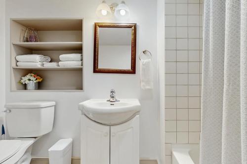 a bathroom with a sink and a toilet and a mirror at Charlotte’s Chateau in New Buffalo