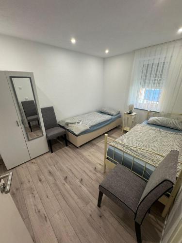 1 Schlafzimmer mit 2 Betten, einem Spiegel und einem Stuhl in der Unterkunft Neues Zentrumnahes Apartment 3 in Ehingen