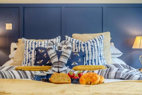 a pile of blankets and pillows on a bed at Firs End in North Walsham