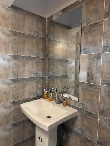 a bathroom with a sink and a mirror at Alchemist Abode - Country Club Apartments in Islamabad