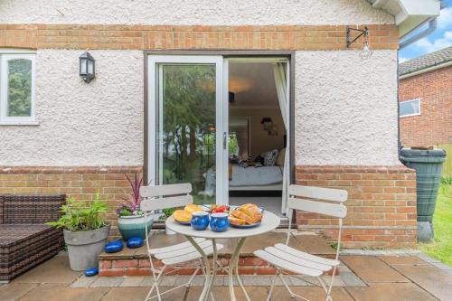 a table with a plate of food on a patio at Firs End in North Walsham