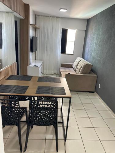 a living room with a table and a couch at Apartamento com 2 quartos de frente para o mar in Maceió
